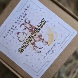 Close up of a birthday card with a reindeer illustration and colorful confetti resting on a brown box