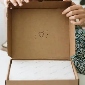 Heartfelt surprise gift in a cardboard box being opened indoors.